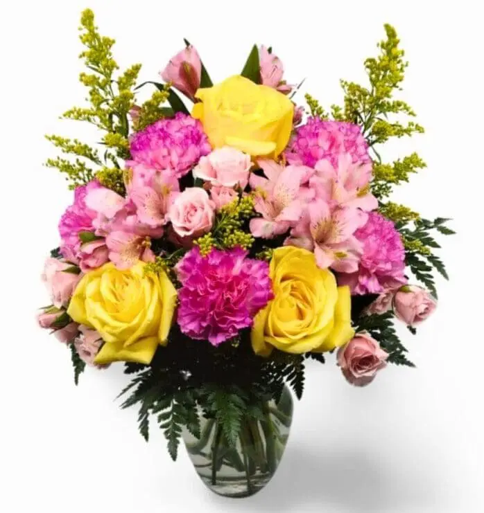 arrangement with bright, sunny yellow roses, delicate solidago, charming pink Peruvian lilies, sweet pink carnations, dainty pink mini carnations, and lush assorted greenery