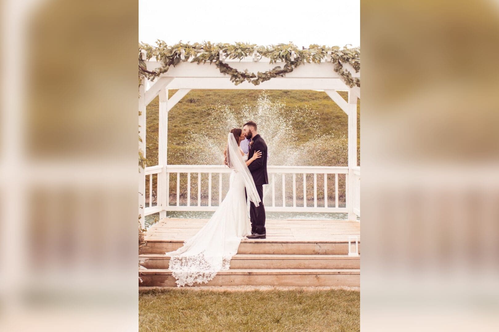 Bride and groom kissing at wedding ceremony.