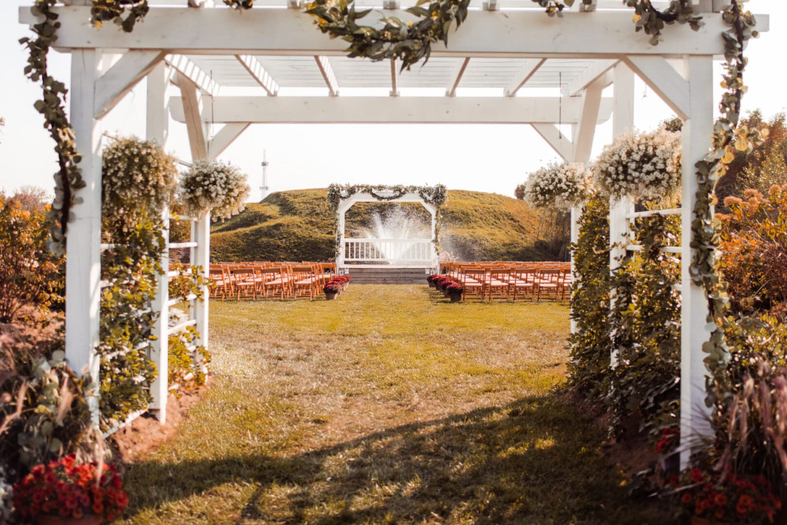 Outdoor wedding ceremony setup with white arbor.